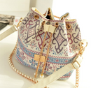 Ethnic style canvas bucket bag designed with intricate patterns and golden chain accents.