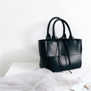 Vintage women's woven crossbody handbag in sleek black leather design on white background.