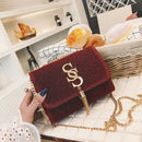 Fringe crossbody bag displayed on a table next to pastries, showcasing its stylish design and gold embellishments.