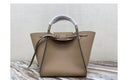 Versatile shoulder crossbody tote bag in beige with unique handle design on a textured surface.