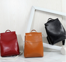 Stylish travel backpack for women in red, orange, and black colors displayed against a modern white background.