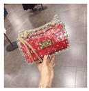 Hand holding a trendy red Chain Bag, Crossbody Mini Bag, Transparent Jelly Bag with rivet design and gold chain.
