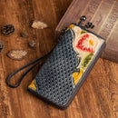 Hand-painted leather clutch purse features floral design, elegantly crafted with premium materials and a wrist strap.