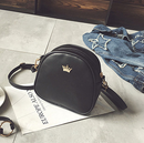 Crown Mini Shoulder Crossbody Bag in black with gold crown detail on a grey surface.