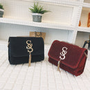 Fringe crossbody bag in black and red with gold accents and tassels on display in a chic setting.