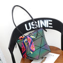 Stylish women's versatile handbag with a unique geometric design and colorful scarf on a chair.