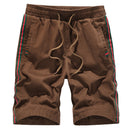 Loose casual sport pants in brown with striped details and drawstring waistband for men.