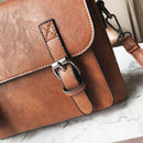 Close-up of a stylish tassel handbag for modern women with brown leather finish and buckle detail.