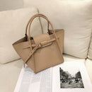 Versatile shoulder crossbody tote bag displayed on a cozy sofa with a magazine beneath it.