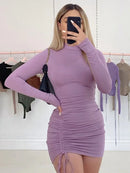Black turtleneck bodycon mini dress showcased on a model in a trendy boutique setting.