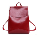 Stylish travel backpack for women in red PU material with a cowhide exterior and secure zipper closure.