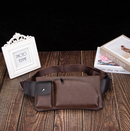 Versatile waist bag in brown PU leather placed on a wooden table next to photo frame and books.