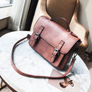 Tassel handbag for modern women, stylish commuter bag in brown leather on a marble table.