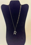 Stylish women's pendant necklace featuring a rhinestone letter R, displayed on a necklace stand.