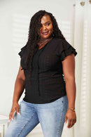 Model wearing an eyelet flutter sleeve top with tie-neck detail, showcasing a feminine style and elegance.