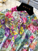 Colorful floral print fabric detail of a vintage evening dress for women, showcasing vibrant patterns and button details.